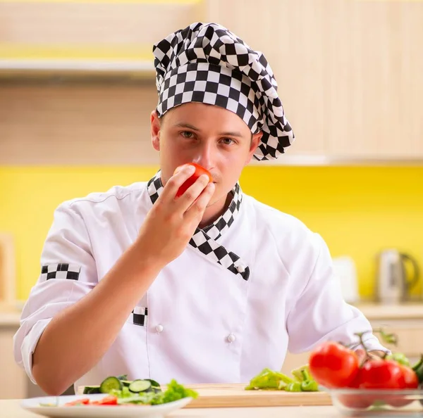 Jonge professionele kok bereidt salade in de keuken — Stockfoto