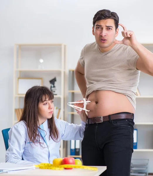 Médico dietista dando consejos a pacientes con sobrepeso de grasa — Foto de Stock