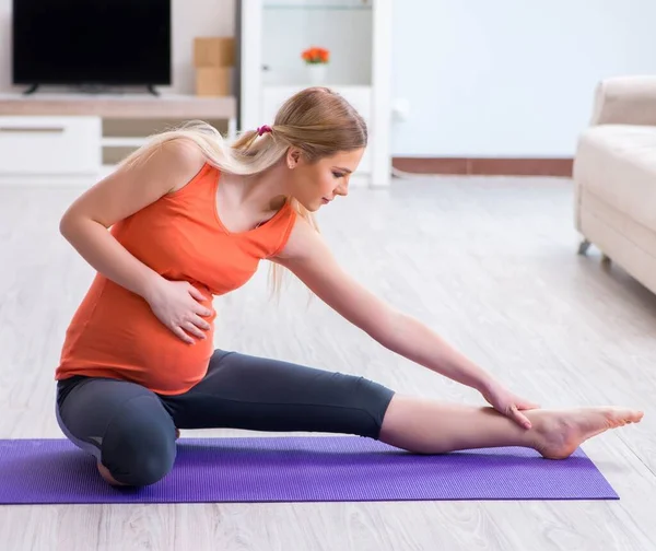 Hamile kadın evde spor yapıyor. — Stok fotoğraf