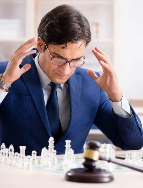 Młody prawnik gra w szachy, szkoląc swoją strategię i tacti. — Zdjęcie stockowe