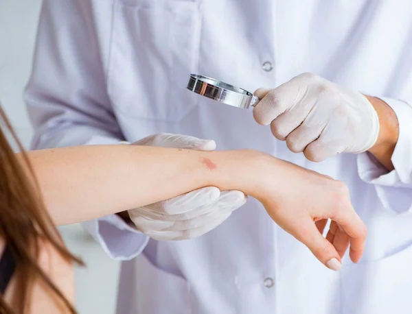 Médico examinando la piel de una paciente femenina — Foto de Stock