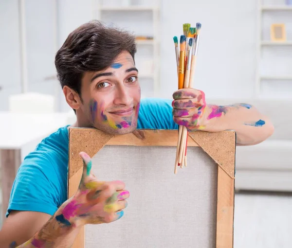 Mladý zábavný umělec pracující na nové malbě ve svém studiu — Stock fotografie