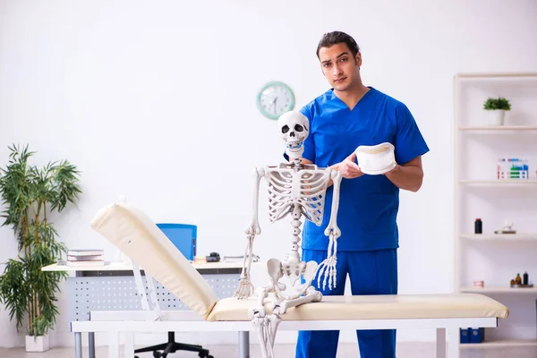 Jovem médico professor demonstrando esqueleto — Fotografia de Stock