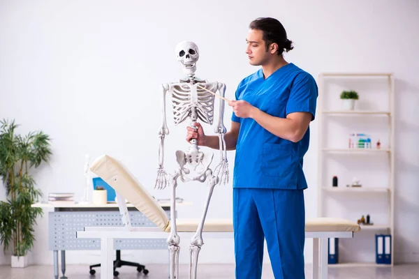 Jeune homme médecin conférencier démontrant squelette — Photo