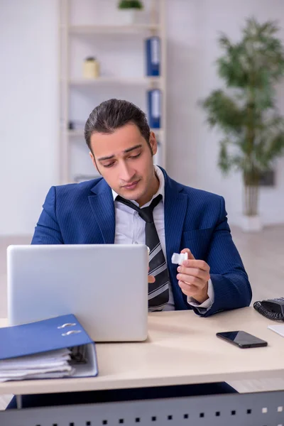 Zieke mannelijke werknemer die op het werk lijdt — Stockfoto