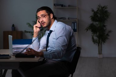 Genç işadamı ofiste geç saatlere kadar çalışıyor.