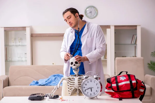 Jovem paramédico visitando paciente esqueleto — Fotografia de Stock