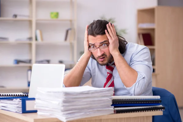 Giovane dipendente maschio infelice con il lavoro eccessivo — Foto Stock