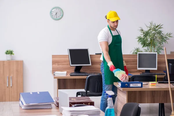 Jovem empreiteiro limpando o escritório — Fotografia de Stock