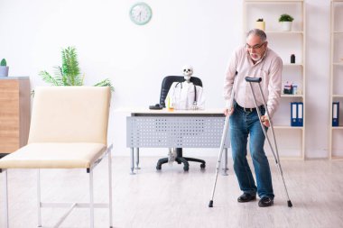 Yaşlı bacağı yaralı bir adam ölü doktoru ziyaret ediyor.