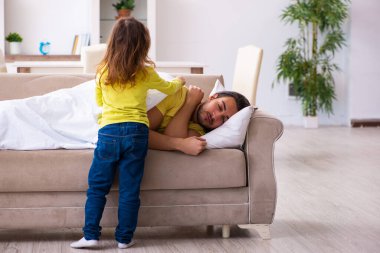 Küçük kız hasta babasına bakıyor.