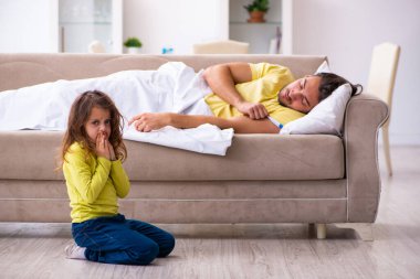 Küçük kız hasta babasına bakıyor.