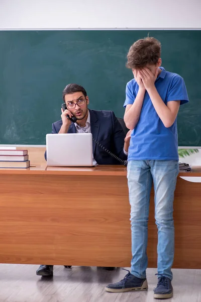 Jeune enseignant et écolier dans la salle de classe — Photo