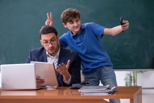 Fiatal férfi tanár és iskolás fiú az osztályteremben — Stock Fotó
