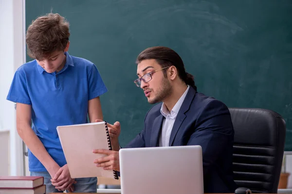 Jeune enseignant et écolier dans la salle de classe — Photo