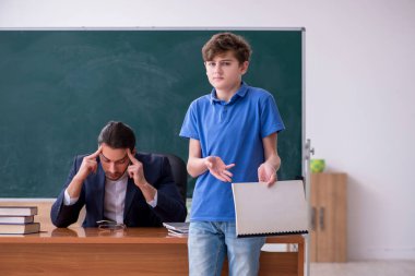 Genç erkek öğretmen ve okul çocuğu sınıfta.