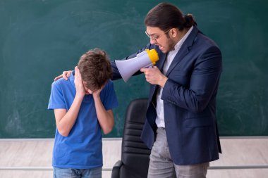 Genç erkek öğretmen ve okul çocuğu sınıfta.