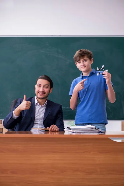 Jonge mannelijke leraar en schooljongen in de klas — Stockfoto