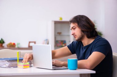 Evden çalışan genç bir adam.