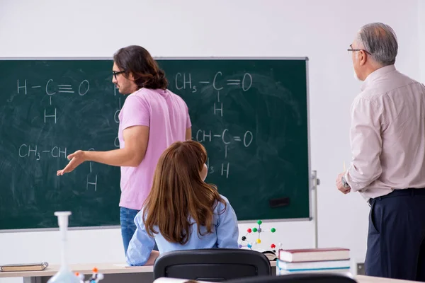 Oude scheikundeleraar en twee leerlingen in de klas — Stockfoto