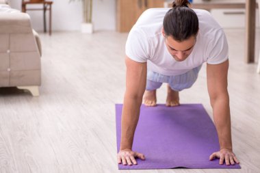 Genç erkek güne sabah egzersizleriyle başlıyor.