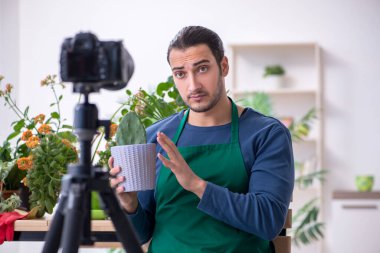 Evin içinde bitkileri olan genç bir erkek bahçıvan.