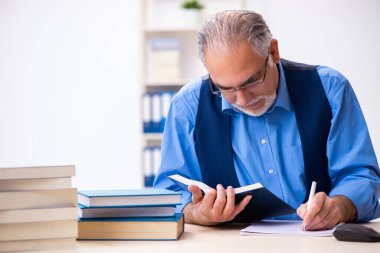 Kitap yazan yaşlı bir erkek yazar.