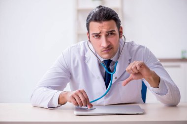 Steteskopu tamir eden genç bir erkek doktor.