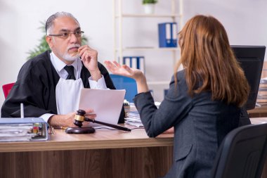 Yaşlı yargıç ve bayan müvekkil büroda.