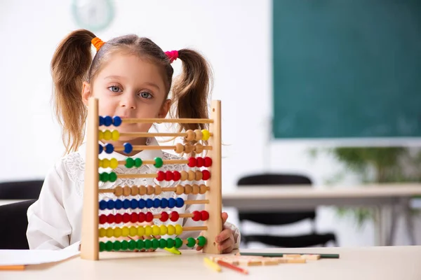 Liten flicka med abacus i klassrummet — Stockfoto