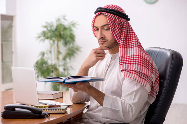 Young male arab employee working in the office
