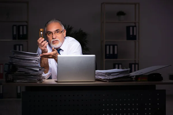 Viejo empleado trabajando hasta tarde en el lugar de trabajo —  Fotos de Stock