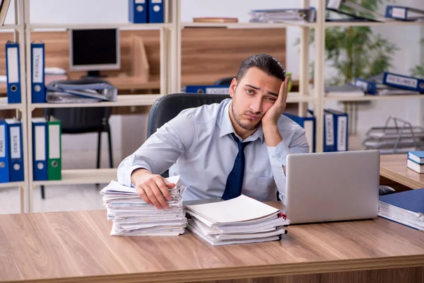 Joven empleado masculino infeliz con el trabajo excesivo — Foto de Stock