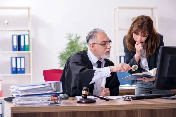 Oude mannelijke rechter en zijn jonge secretaresse op kantoor — Stockfoto