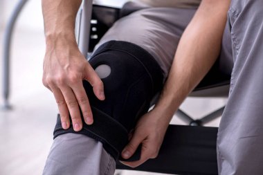 Tekerlekli sandalyedeki yaralı genç adam.