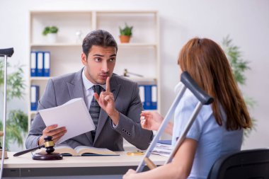 Yaralı genç kadın ve erkek avukat mahkeme salonunda.