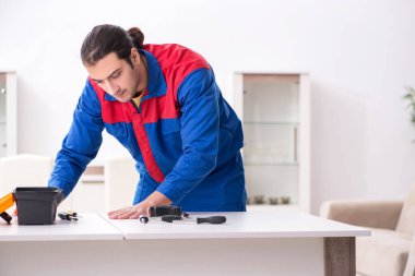 Genç erkek marangoz içeride çalışıyor.