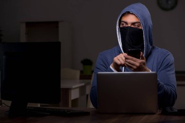 Erkek bilgisayar korsanı, güvenlik duvarını geç saatlerde hackliyor.