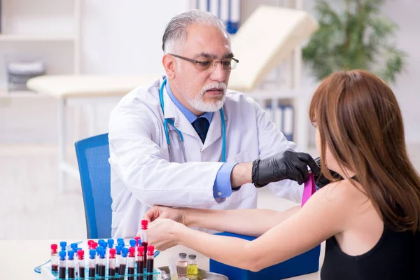 Genç kadın yaşlı erkek doktoru ziyaret ediyor. — Stok fotoğraf