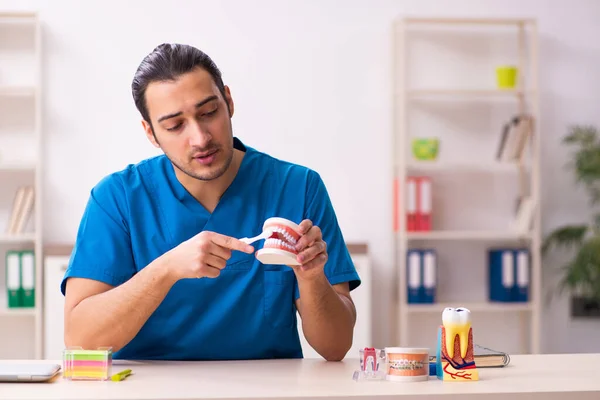 Jonge mannelijke tandarts werkzaam in de kliniek — Stockfoto