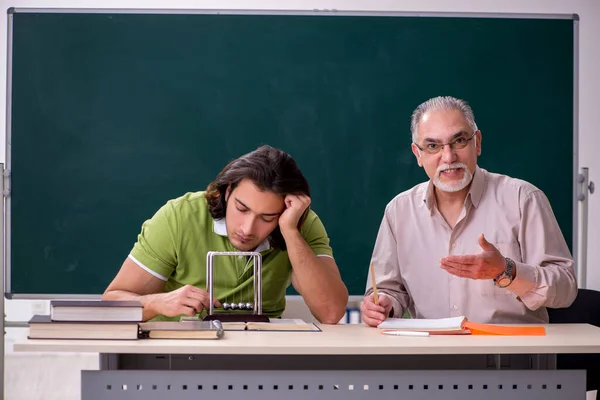 Oude hoogleraar natuurkunde en jonge student in de klas — Stockfoto