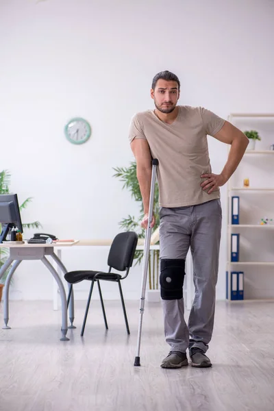 Jovem perna ferido homem com muletas — Fotografia de Stock
