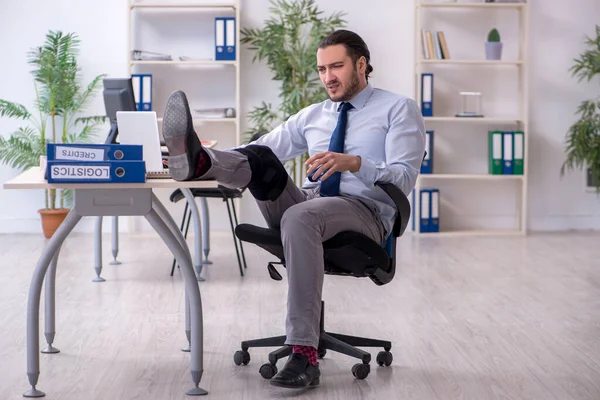 Young leg injured employee working in the office — Stock Photo, Image