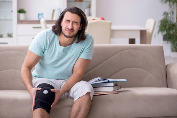 Mladá noha zraněný student studium doma — Stock fotografie