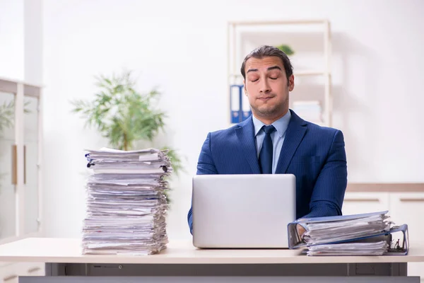 Joven empleado masculino infeliz con el trabajo excesivo —  Fotos de Stock