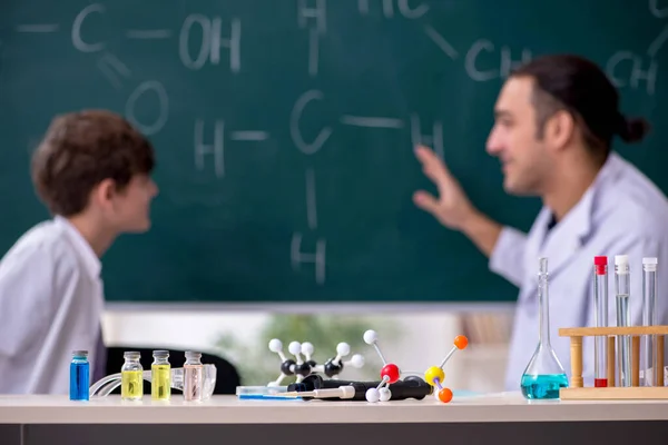 Young chemistry teacher and schoolboy in the classroom — Stock Photo, Image