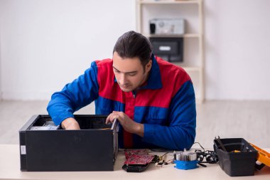 Bilgisayar tamir eden genç bir erkek tamirci.