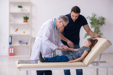 Genç baba ve kızı yaşlı doktoru ziyaret ediyor.