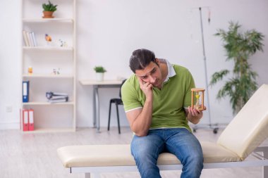 Genç adam klinikte doktor bekliyor.