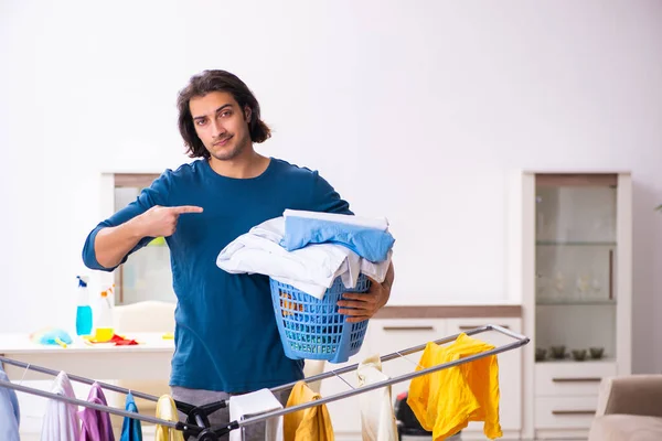 Jovem marido fazendo roupas de engomar em casa — Fotografia de Stock